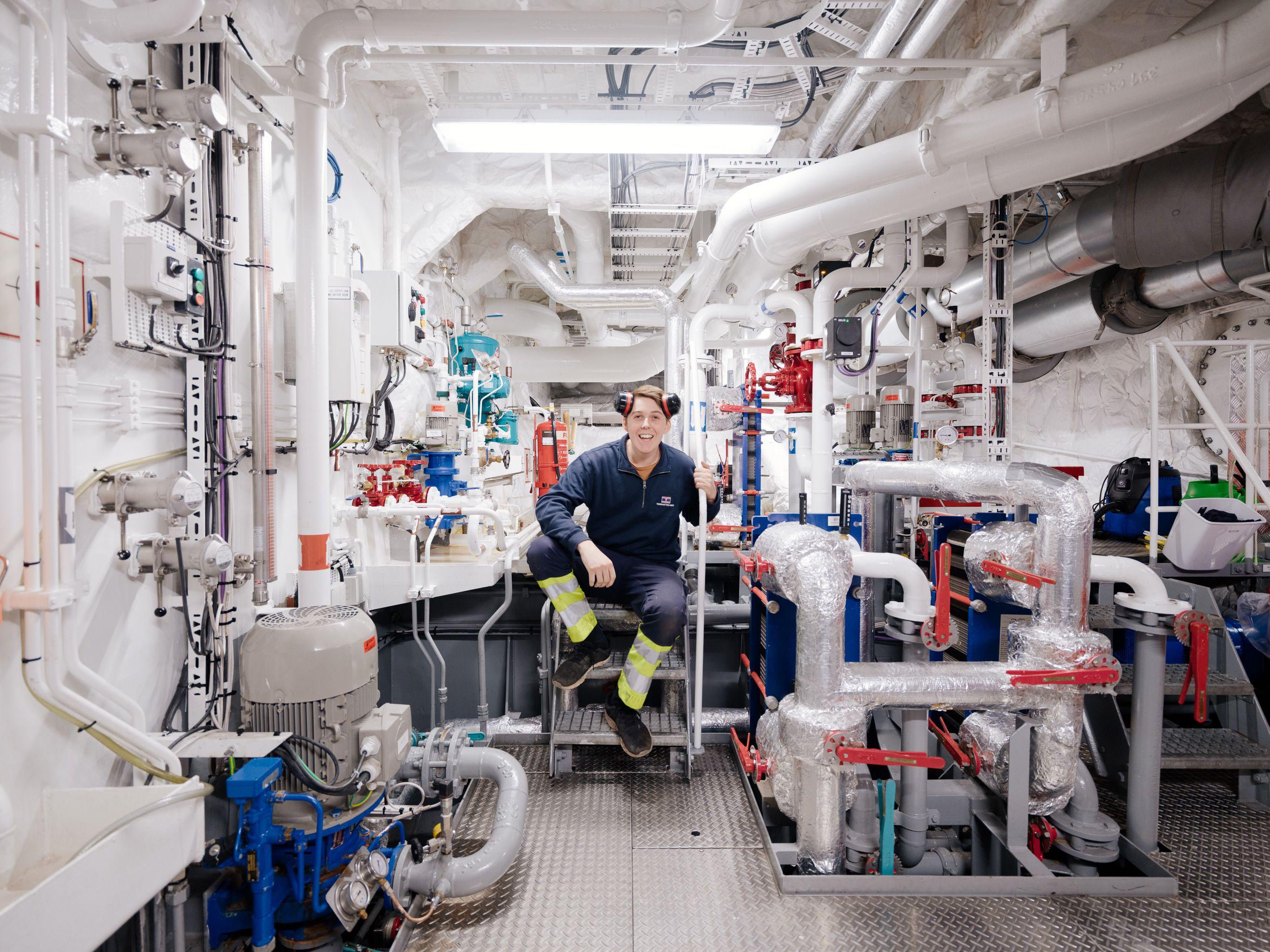 Photo of an employee working in the engine room of a ship