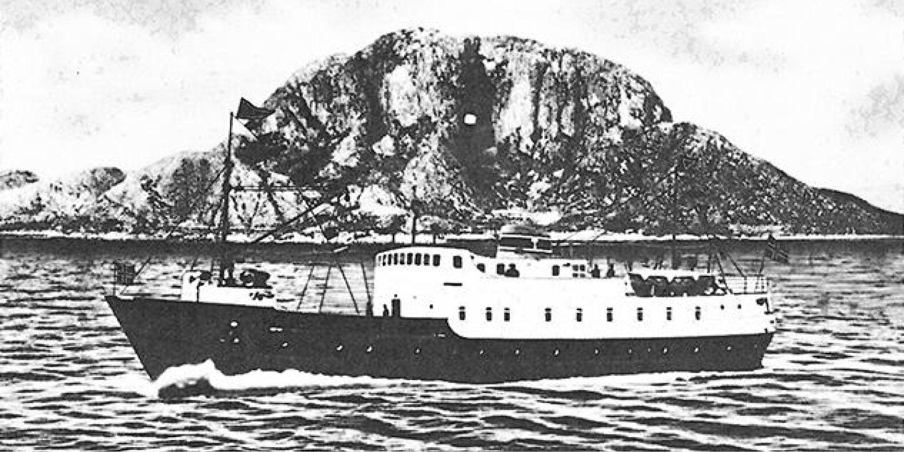 Skipet Torghatten på sjøen med Torghatten fjellet i bakgrunnen. 